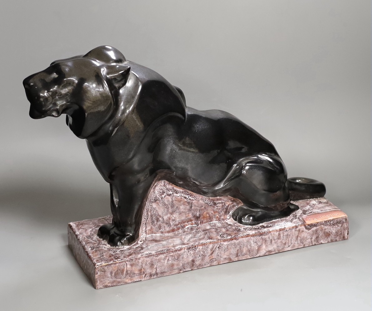 A French Art Deco ceramic model lion, signed Francisque, 31cms high